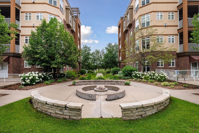 view of community featuring a fire pit and a patio