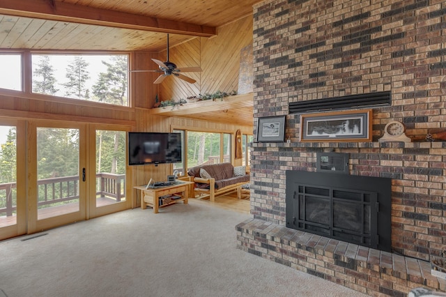 carpeted living room featuring ceiling fan, beamed ceiling, wood ceiling, a brick fireplace, and high vaulted ceiling