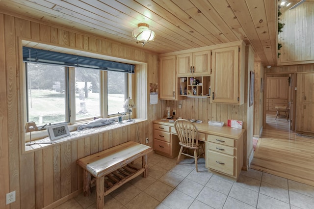 tiled office space featuring wood ceiling, wood walls, and built in desk