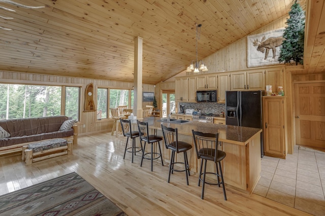 kitchen featuring wood ceiling, wood walls, sink, black appliances, and an inviting chandelier