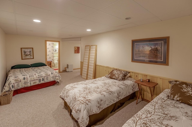 carpeted bedroom with wood walls