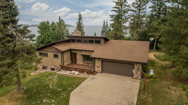 view of front of house with a water view, a front lawn, and a garage