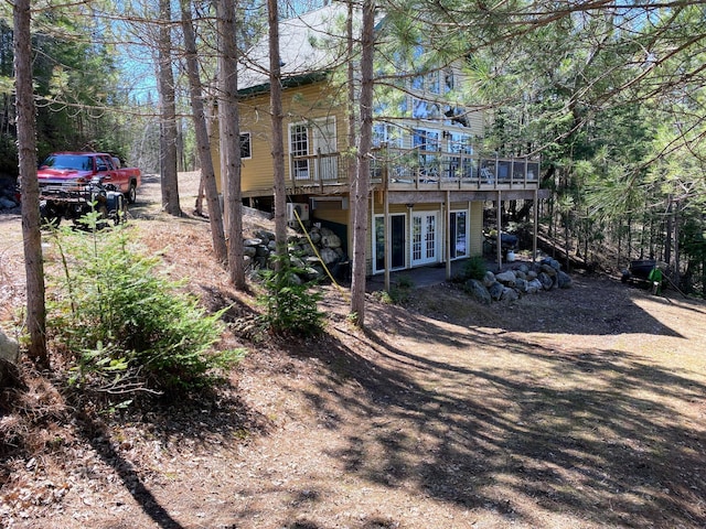 rear view of house with french doors and a wooden deck
