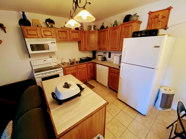 kitchen featuring light tile patterned floors, white appliances, hanging light fixtures, a sink, and light countertops
