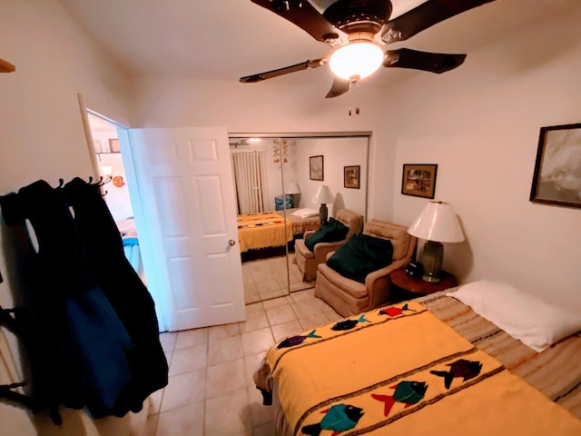 bedroom with light tile patterned floors, a closet, and ceiling fan