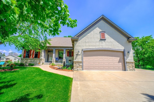 view of front facade featuring covered porch, a front yard, and a garage