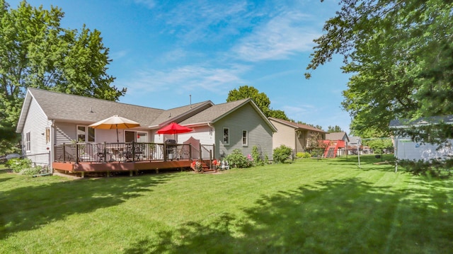 back of property featuring a deck and a lawn