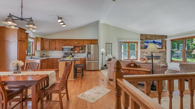 kitchen with a wealth of natural light, vaulted ceiling, and stainless steel appliances