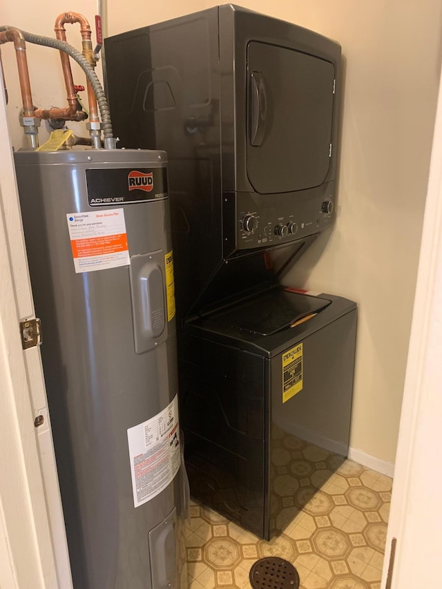 laundry room featuring stacked washer / dryer, electric water heater, laundry area, and baseboards