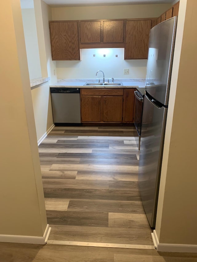 kitchen featuring dark wood-style flooring, light countertops, stainless steel appliances, and a sink