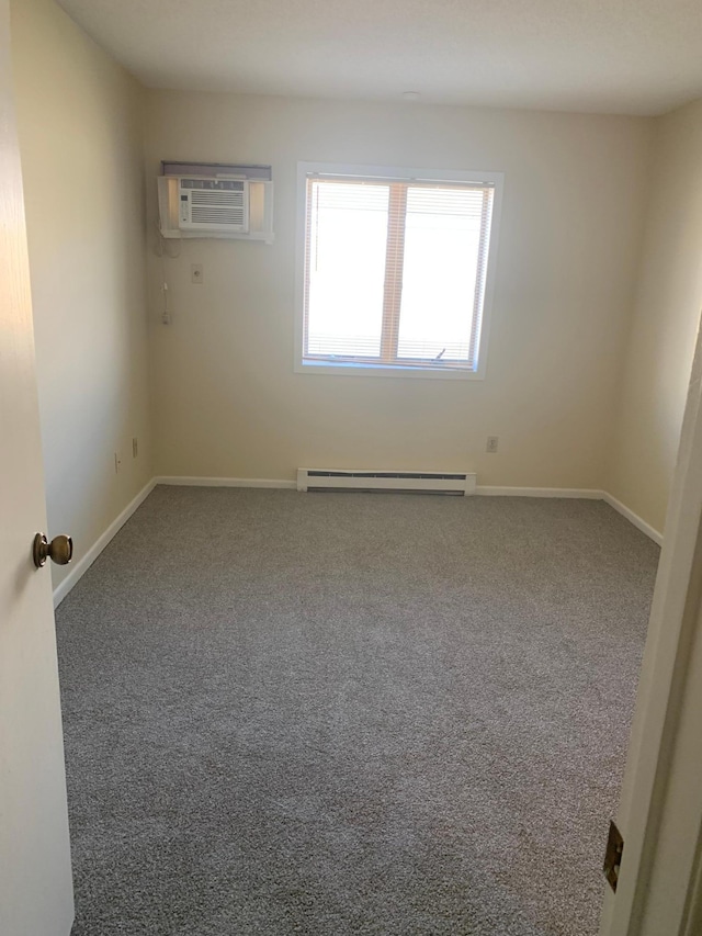 empty room featuring a wall mounted air conditioner, baseboards, a baseboard heating unit, and carpet floors