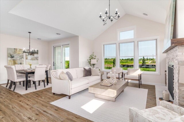 living room featuring a fireplace, light wood-type flooring, and a chandelier