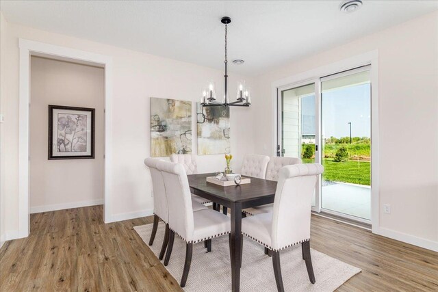 dining area with hardwood / wood-style floors and a chandelier