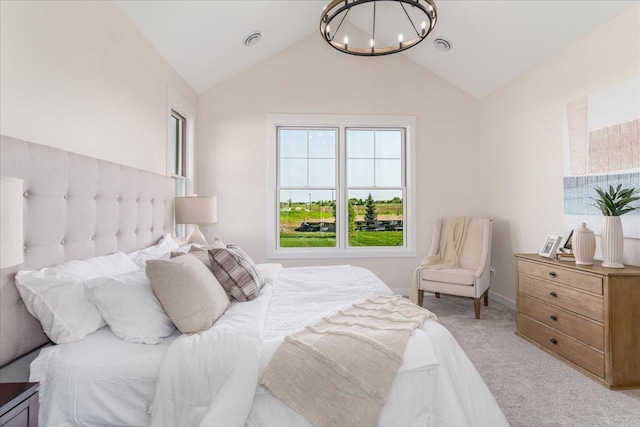 carpeted bedroom with a chandelier and high vaulted ceiling