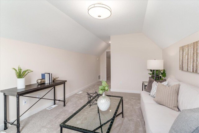 living room with vaulted ceiling and light colored carpet