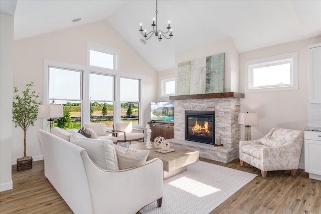 living room with a healthy amount of sunlight, high vaulted ceiling, and light hardwood / wood-style flooring