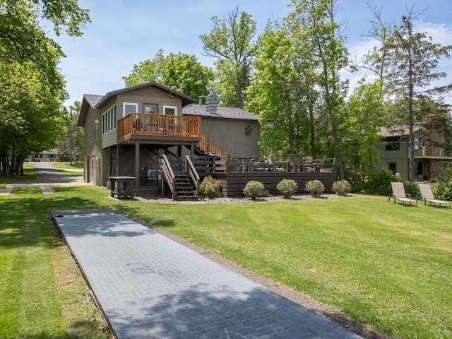 rear view of property featuring a wooden deck, stairway, and a yard