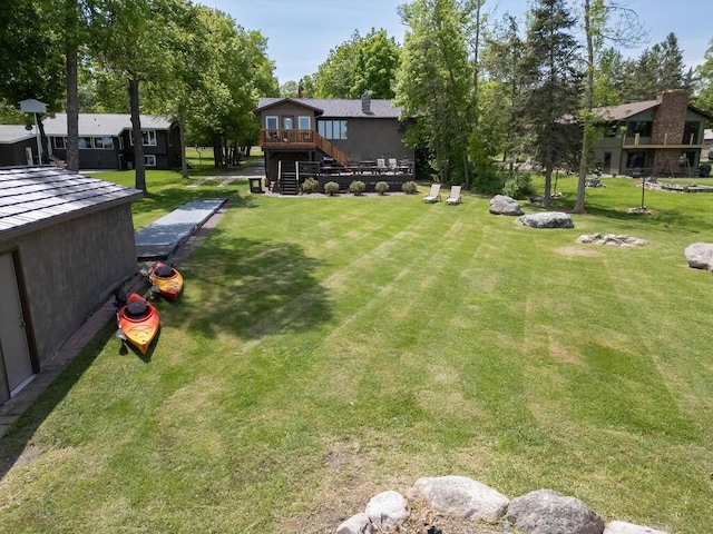 view of grassy yard with a deck