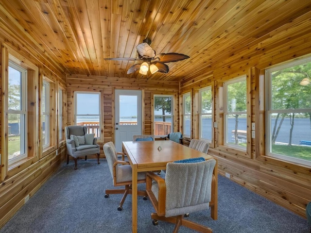 sunroom with wood walls, carpet floors, wood ceiling, and plenty of natural light