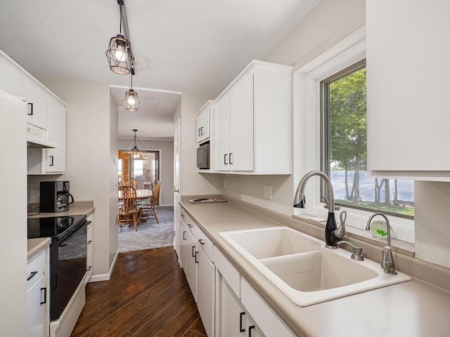 kitchen featuring a sink, black electric range oven, under cabinet range hood, and plenty of natural light