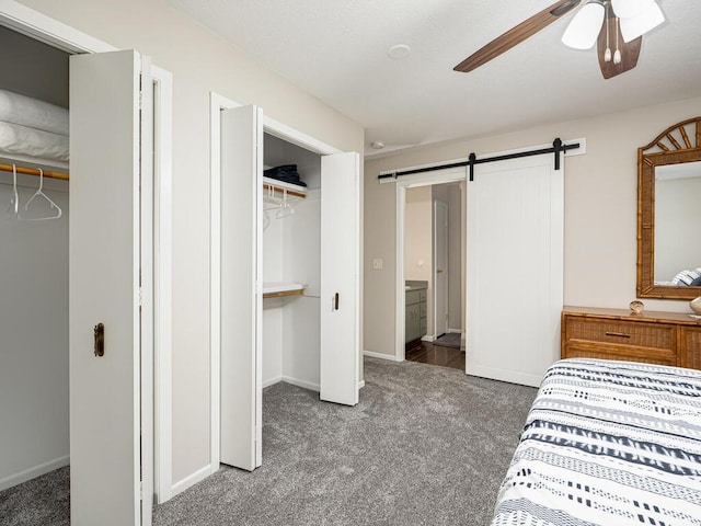bedroom with carpet, a barn door, baseboards, and a ceiling fan