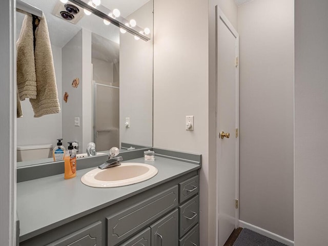 bathroom featuring a shower stall, vanity, and toilet