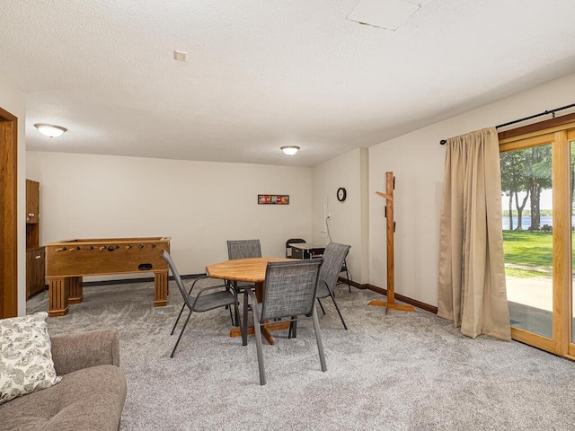 dining space featuring light colored carpet, baseboards, and a textured ceiling