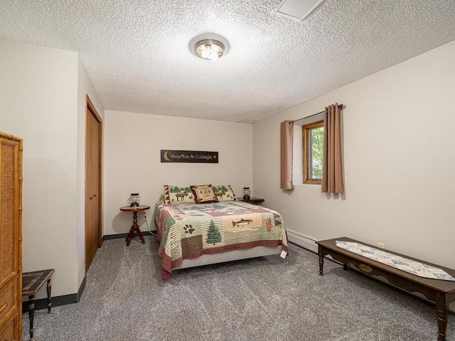 carpeted bedroom with a baseboard heating unit, a textured ceiling, and baseboards
