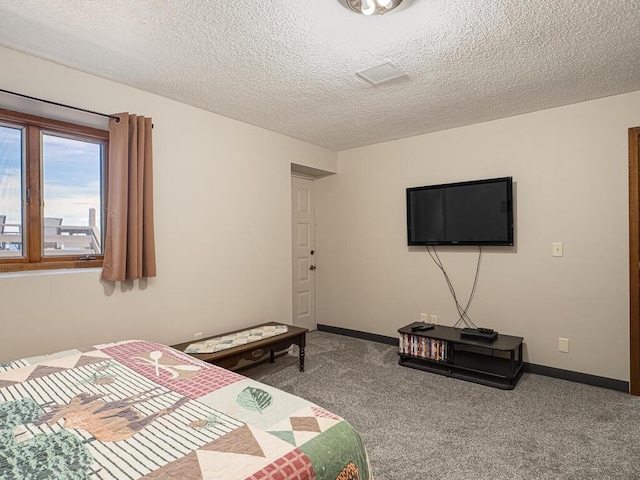 bedroom featuring a textured ceiling, carpet flooring, and baseboards