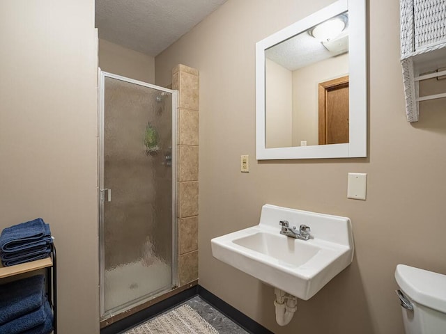 full bathroom with a stall shower, toilet, and a sink