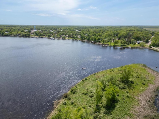 drone / aerial view of a large body of water and a heavily wooded area
