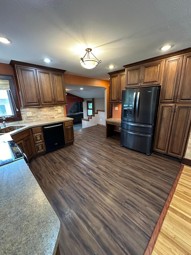 921 11th St N, Mountain Lake, MN 56159 - kitchen with a sink, black appliances, dark wood finished floors, backsplash, and light countertops
