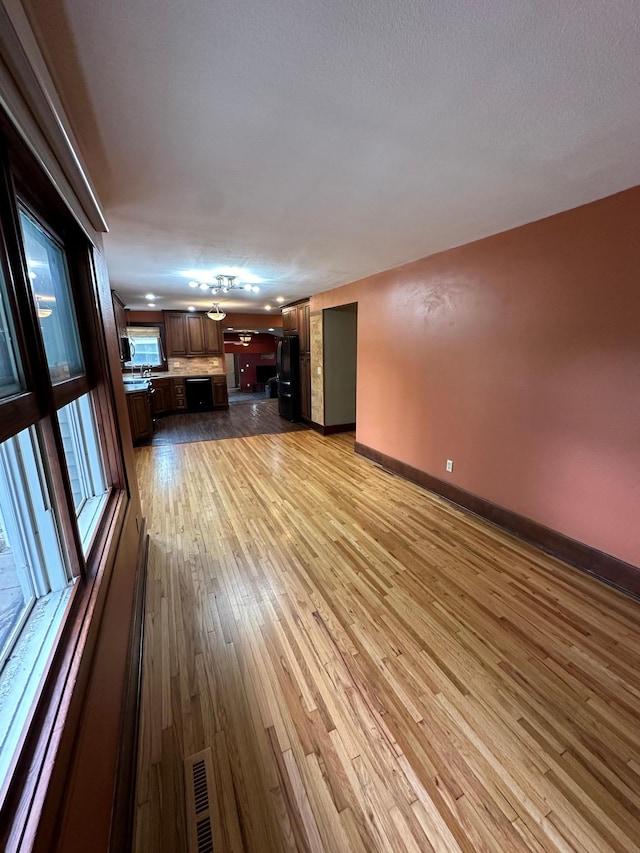 unfurnished living room with a textured ceiling and light wood-type flooring