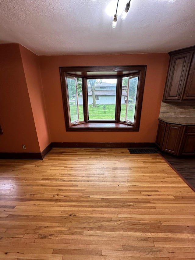 interior space with a textured ceiling and light wood-type flooring