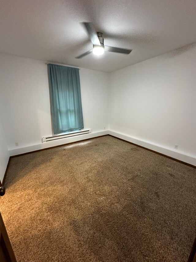 spare room featuring ceiling fan, a textured ceiling, carpet, and a baseboard heating unit