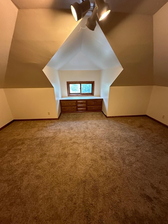 bonus room with carpet floors and vaulted ceiling