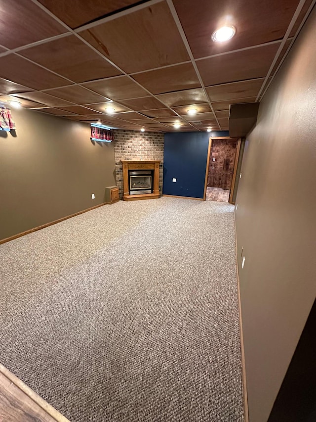 921 11th St N, Mountain Lake, MN 56159 - finished below grade area featuring a brick fireplace, baseboards, carpet flooring, and a drop ceiling