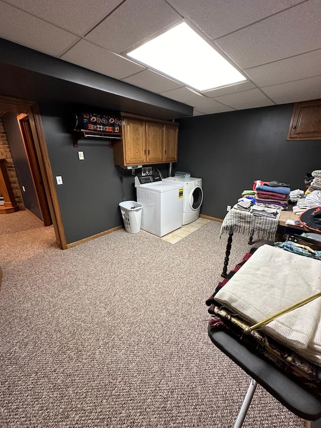 interior space featuring washing machine and clothes dryer, light carpet, and a paneled ceiling