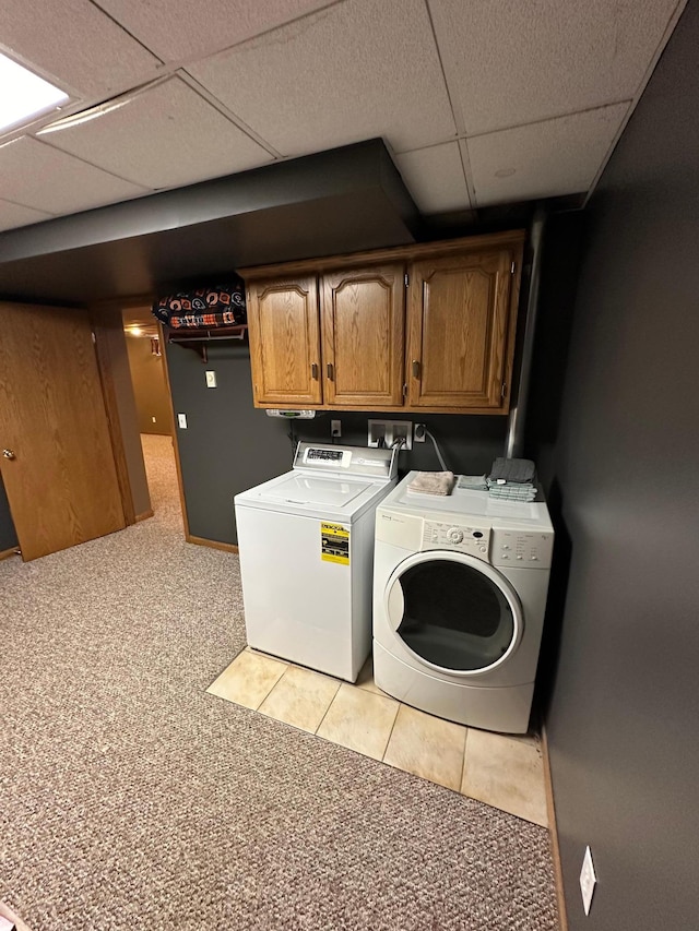 921 11th St N, Mountain Lake, MN 56159 - laundry area featuring washing machine and dryer, light colored carpet, cabinet space, and light tile patterned floors
