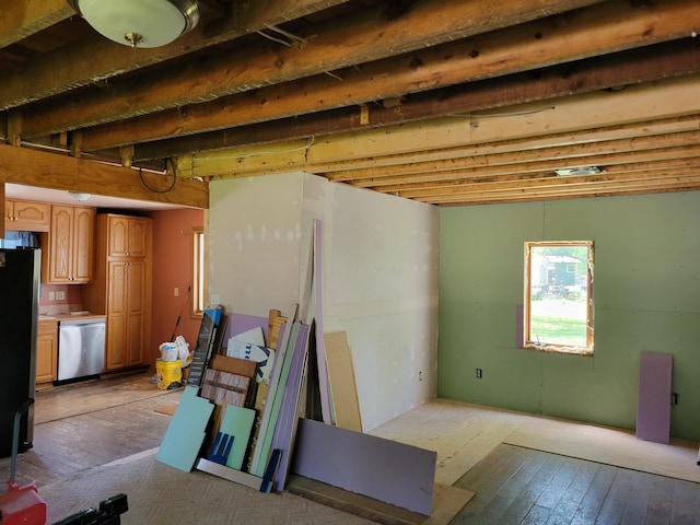 basement featuring refrigerator and light hardwood / wood-style flooring