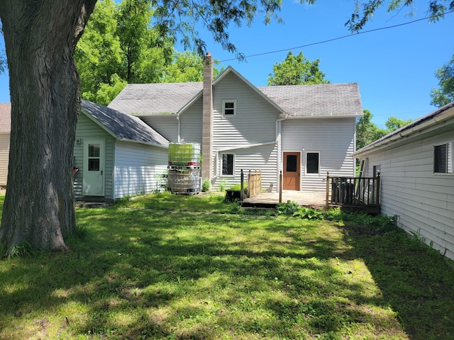 rear view of property with a deck and a yard