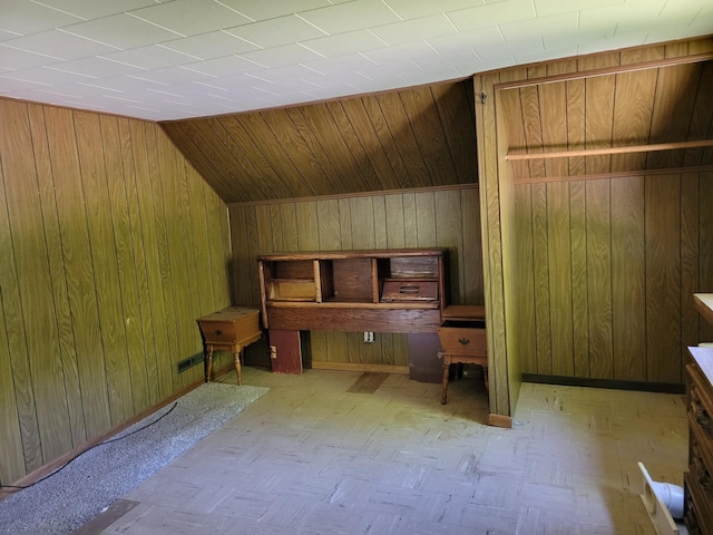 additional living space featuring wood walls and vaulted ceiling