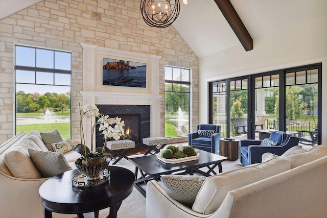 living room with a fireplace, beamed ceiling, a chandelier, and high vaulted ceiling