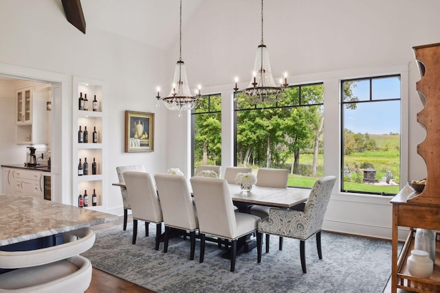 dining room featuring built in features, wood-type flooring, high vaulted ceiling, and an inviting chandelier