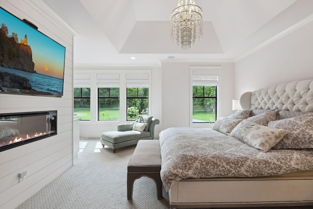 carpeted bedroom featuring a raised ceiling and an inviting chandelier