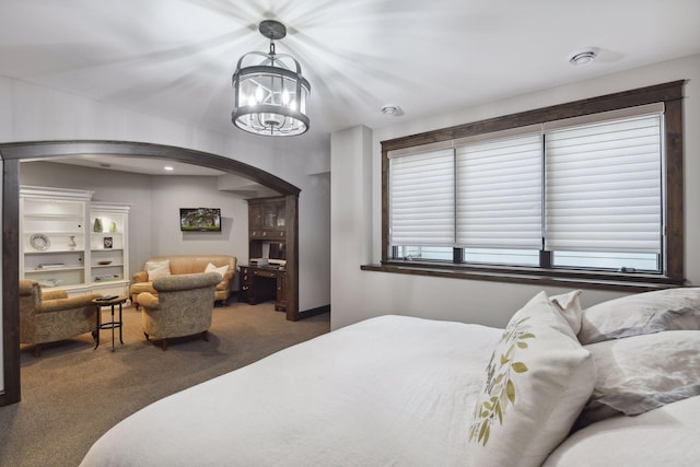 carpeted bedroom with a notable chandelier