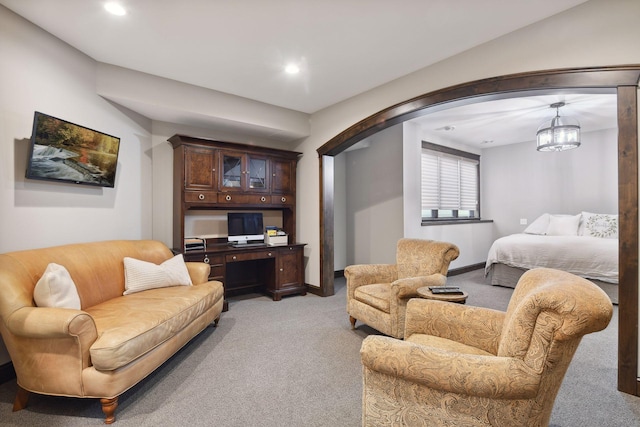 carpeted living room featuring a chandelier