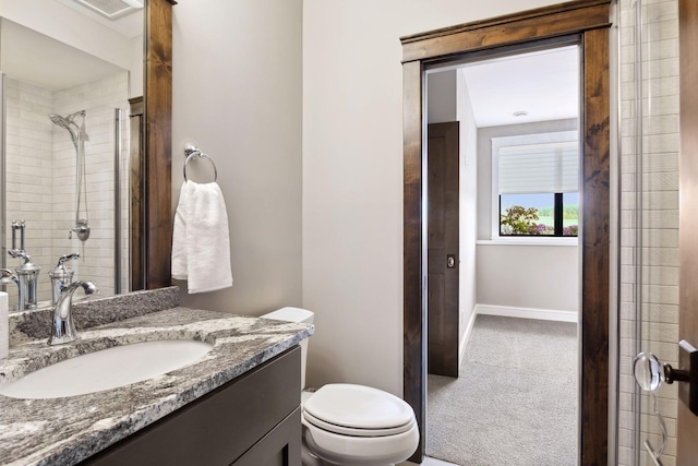 bathroom featuring vanity, toilet, and a shower with shower door