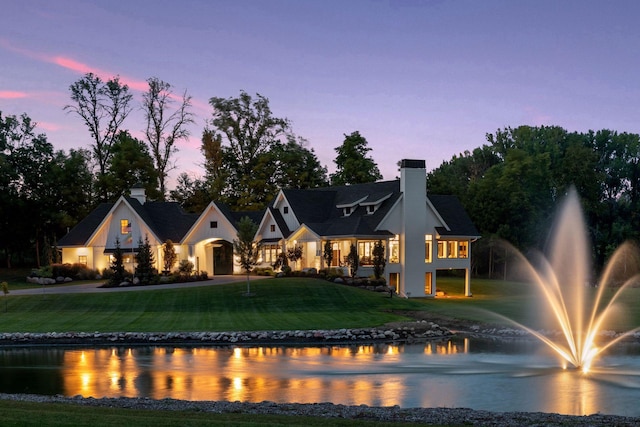 view of front of home featuring a yard and a water view