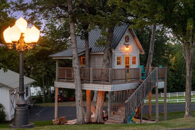 back house at dusk featuring a wooden deck